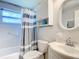 Clean bathroom with white vanity, tub shower, and gray striped shower curtain at 2248 Society Dr, Holiday, FL 34691
