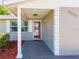 Inviting front entrance with a reddish-brown door, white columns, and neatly landscaped area at 2248 Society Dr, Holiday, FL 34691