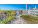 Walkway to beach with wooden railings, beach rules sign, and dune vegetation at 142 Beach Ave, Redington Shores, FL 33708