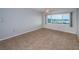 Spacious bedroom with neutral paint, tile flooring, a ceiling fan, and a large window offering water views at 100 Bluff View Dr # 405C, Belleair Bluffs, FL 33770