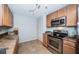 Galley kitchen with stainless steel appliances, granite countertops, and tiled floors at 100 Bluff View Dr # 405C, Belleair Bluffs, FL 33770