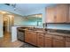 Charming kitchen featuring granite countertops, stainless steel dishwasher, and warm wood cabinetry at 100 Bluff View Dr # 405C, Belleair Bluffs, FL 33770