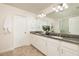 Bathroom boasts a double vanity with granite countertop, white cabinetry and tile floors at 17860 Althea Blue Pl, Lutz, FL 33558