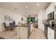 Open concept kitchen with granite counters, island, and white cabinets, flowing into the dining and living areas at 17860 Althea Blue Pl, Lutz, FL 33558