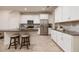 Bright kitchen featuring white cabinets, granite countertops, stainless steel appliances, and breakfast bar at 17860 Althea Blue Pl, Lutz, FL 33558