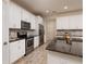Modern kitchen with white cabinets, granite countertops, stainless steel appliances, and tile flooring at 17860 Althea Blue Pl, Lutz, FL 33558