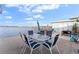 Waterfront patio with table, chairs, and umbrella at 1840 Shore S Dr # 5, South Pasadena, FL 33707