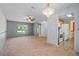 Spacious living room with carpet flooring, chandelier, and view into kitchen at 10534 Hardwood Ct, Port Richey, FL 34668
