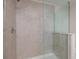 Modern shower with glass enclosure and neutral tile at 17860 Althea Blue Pl, Lutz, FL 33558