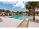 Community pool with lounge chairs and palm trees at 17860 Althea Blue Pl, Lutz, FL 33558