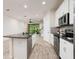 Open kitchen with island, stainless steel appliances, and white cabinets at 17860 Althea Blue Pl, Lutz, FL 33558