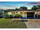 Charming single-story home with well-maintained lawn, mature trees, and private driveway under a colorful sky at 6220 5Th S Ave, St Petersburg, FL 33707