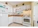 Small kitchen with white cabinets and appliances at 6220 5Th S Ave, St Petersburg, FL 33707