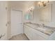 A bright bathroom with dual sinks, marbled countertops, and white cabinets at 9883 Sago Point Dr, Seminole, FL 33777