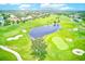 Scenic aerial of the lush golf course showcasing a serene pond, manicured greens, and mature trees at 9883 Sago Point Dr, Seminole, FL 33777