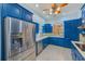 Kitchen featuring stainless steel refrigerator and appliances, blue cabinetry and designer backsplash at 9883 Sago Point Dr, Seminole, FL 33777