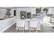 Modern kitchen island with white quartz countertop and two light-grey chairs at 12404 Capri N Cir # 0, Treasure Island, FL 33706