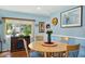 Dining room with a round wooden table, four chairs, and a view of a window at 2430 Brazilia Dr # 24, Clearwater, FL 33763