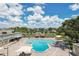 Community pool with plenty of lounge chairs and umbrellas for relaxing at 2430 Brazilia Dr # 24, Clearwater, FL 33763