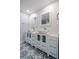 Modern bathroom with double vanity, updated fixtures, and patterned tile floor at 50 Coe Rd # 125, Belleair, FL 33756
