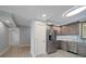 Modern kitchen with stainless steel refrigerator and gray cabinets at 50 Coe Rd # 125, Belleair, FL 33756