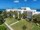 White building with palm trees and manicured lawn, offering waterfront views at 50 Coe Rd # 125, Belleair, FL 33756