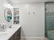 Bathroom with double vanity, built-in shelving, and walk-in shower at 3047 Enisglen Dr, Palm Harbor, FL 34683