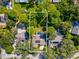 Aerial view showcasing home with pool, solar panels, and lush landscaping at 3047 Enisglen Dr, Palm Harbor, FL 34683