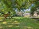 Shady backyard with playset and trampoline under large trees at 3047 Enisglen Dr, Palm Harbor, FL 34683