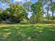 Spacious backyard with large grassy area, playset, and trampoline at 3047 Enisglen Dr, Palm Harbor, FL 34683