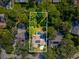 Aerial view showcasing home with pool, solar panels, and lush landscaping at 3047 Enisglen Dr, Palm Harbor, FL 34683