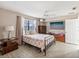 Bedroom with a coral comforter, ceiling fan, and large TV at 3047 Enisglen Dr, Palm Harbor, FL 34683