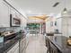 Open kitchen with granite counters, stainless steel appliances, and breakfast bar at 3047 Enisglen Dr, Palm Harbor, FL 34683