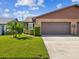 Front view of a brick home with a two-car garage at 3332 Mcmath Dr, Palm Harbor, FL 34684