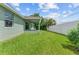 Side yard of the house with green grass and white fence at 105 Dartmouth Rd, Venice, FL 34293