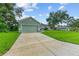 Front view of the house with a light green exterior, a garage, and a well-maintained lawn at 105 Dartmouth Rd, Venice, FL 34293