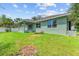Backyard of a house with green grass, a covered patio, and a white fence at 105 Dartmouth Rd, Venice, FL 34293