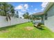 Backyard view showcasing a partially visible house, green grass, and a white fence at 105 Dartmouth Rd, Venice, FL 34293