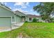 House exterior showcasing a light green color, a brown roof, and a neatly manicured lawn at 105 Dartmouth Rd, Venice, FL 34293