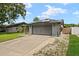 Gray house exterior with solar panels and a two-car garage at 1608 Gunsmith Dr, Lutz, FL 33559