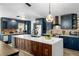 Modern kitchen with dark blue cabinets, wood island, and quartz countertops at 1608 Gunsmith Dr, Lutz, FL 33559