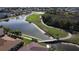 Aerial view of a golf course community with lake and bridge at 24327 Buckingham Way, Punta Gorda, FL 33980