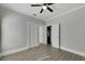Bedroom with ceiling fan, grey walls, wood-look flooring and access to bathroom at 907 E North Bay St, Tampa, FL 33603