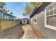 Landscaped side yard with a path leading to a detached workshop at 907 E North Bay St, Tampa, FL 33603