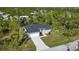 Aerial view of a house with a paved driveway and surrounding landscape at 10110 Bay State Dr, Port Charlotte, FL 33981