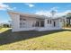 View of the back of a single story house with a large covered patio at 10110 Bay State Dr, Port Charlotte, FL 33981