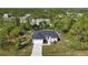 Single-story house with a gray roof and a large front yard surrounded by trees at 14480 Argus Ln, Port Charlotte, FL 33981