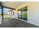 Covered back porch with gray tile, offering a seamless transition to the outdoors through sliding glass doors at 14346 San Domingo Blvd, Port Charlotte, FL 33981