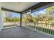 Covered back porch overlooking a lush yard featuring a gray tile floor and white railing at 14346 San Domingo Blvd, Port Charlotte, FL 33981