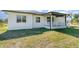 Bright backyard with a view of the covered back porch and lush green lawn at 14346 San Domingo Blvd, Port Charlotte, FL 33981
